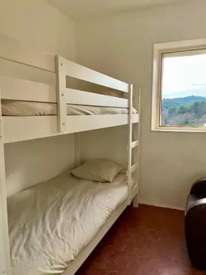 a bedroom with two bunk beds and a window at Maison & Jardin Coeur Luberon classé 4 étoiles in Peypin-dʼAigues