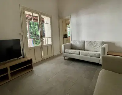 a living room with a couch and a flat screen tv at Maison & Jardin Coeur Luberon classé 4 étoiles in Peypin-dʼAigues
