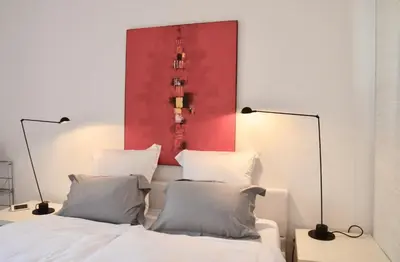 a bedroom with a red painting above a bed at Les Cerisiers maison bertuli climatisé, Piscine chauffée, lit King size, classé 5 étoiles in Oppède