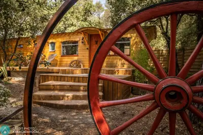 a log cabin with a wheel in front of it at Interlude in Lambesc