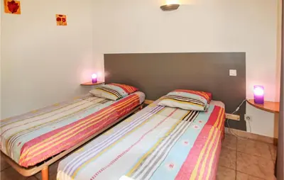 two beds sitting next to each other in a room at Cozy Home In Carpentras in Carpentras