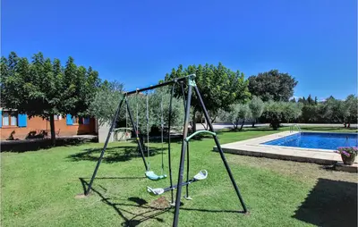 a swing set in a yard next to a pool at Cozy Home In Carpentras in Carpentras