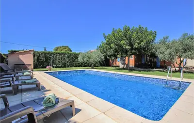 a swimming pool with chairs next to a house at Cozy Home In Carpentras in Carpentras