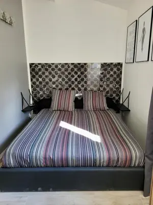 a bed in a bedroom with a striped bedspread at Les Prairies de l'Encrême in Céreste