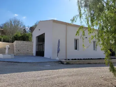 a large white building with a large door at Les Prairies de l'Encrême in Céreste