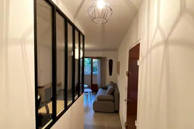 a hallway with a living room with a couch and a mirror at Appartement T2 Cosy sur Aix in Aix-en-Provence