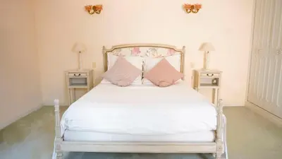 a bedroom with a white bed with pink pillows at Chambres dans le Luberon - Bois Romay in La Bastide-des-Jourdans
