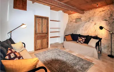 a living room with a couch and a stone wall at 2 Bedroom Amazing Home In Apt in Apt