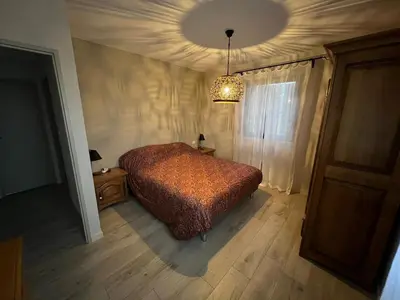 a bedroom with a bed and a chandelier at Le Cabanon de Nans. Gîte de charme en Provence. in Grans