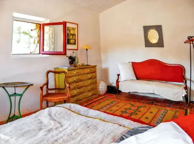 a bedroom with a bed and a dresser and a chair at Villa élégante avec piscine privée à Ansouis, vues montagne in Ansouis