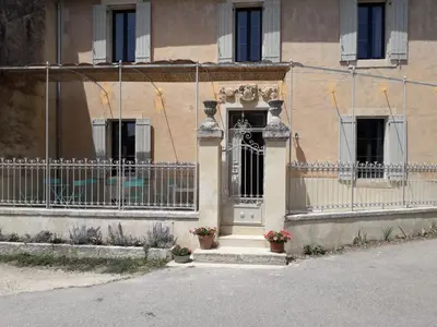 a building with a gate and a door at MAISON BOURGUES in Lioux