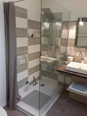 a bathroom with a glass shower and a sink at Studio avec kitchenette du sentier des ocres in Roussillon