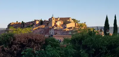 a village on top of a hill with houses at Studio avec kitchenette du sentier des ocres in Roussillon