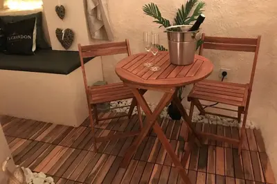 a small table with two chairs and a potted plant at Les Secrets d'Alcôve, nuits Romantiques avec SPA in Aix-en-Provence