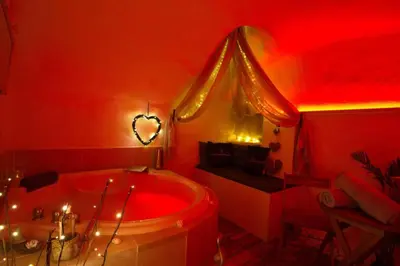 a red bathroom with a tub and a sink at Les Secrets d'Alcôve, nuits Romantiques avec SPA in Aix-en-Provence