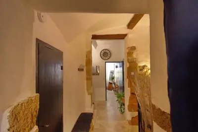 a hallway in a house with a clock on the wall at Les Secrets d'Alcôve, nuits Romantiques avec SPA in Aix-en-Provence