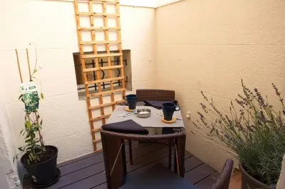 a table and chairs on a patio with plants at Les Secrets d'Alcôve, nuits Romantiques avec SPA in Aix-en-Provence