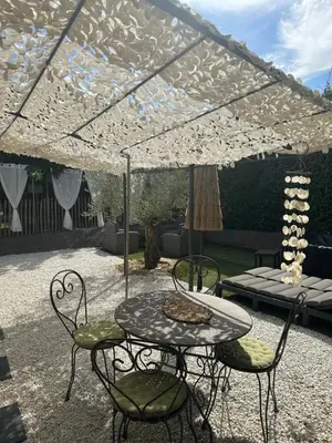 a patio with a table and chairs under a tent at Petit nid douillet en Luberon avec spa in Ansouis