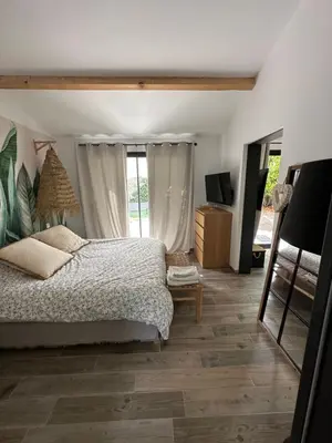 a bedroom with a bed and a large window at Petit nid douillet en Luberon avec spa in Ansouis