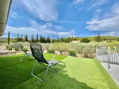 two chairs sitting on a lawn on a balcony at Il y a le Soleil, la Campagne et la Mer in Martigues