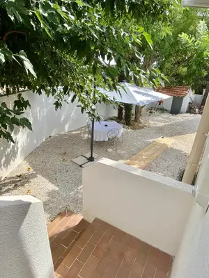 a view of a patio with a table in a yard at Il y a le Soleil, la Campagne et la Mer in Martigues