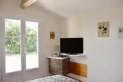 a bedroom with a flat screen tv on a wall at Provence.bienvenue chez nous in Rognes