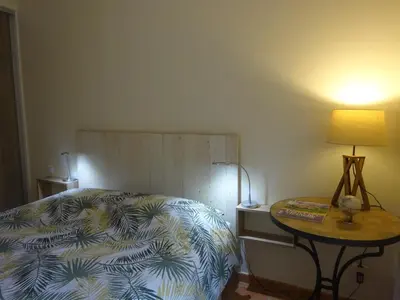 a bedroom with a bed and a table with a lamp at Provence.bienvenue chez nous in Rognes