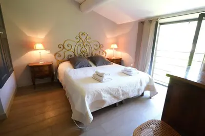 a bedroom with a bed with two towels on it at high standard provencal bastide with heated pool in lourmarin in the luberon, vaucluse. 10 people in Lourmarin