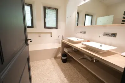 a bathroom with two sinks and a tub and mirror at high standard provencal bastide with heated pool in lourmarin in the luberon, vaucluse. 10 people in Lourmarin