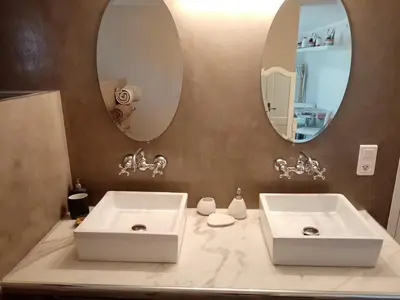 a bathroom with two sinks and two mirrors at Au Coeur du Luberon in Cavaillon