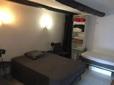 a bedroom with a bed and a small closet at Logement sur pte cour, rez de chaussée, WIFI, CLIM in Vedène