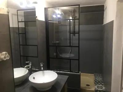 a bathroom with two sinks and a glass shower at Logement sur pte cour, rez de chaussée, WIFI, CLIM in Vedène