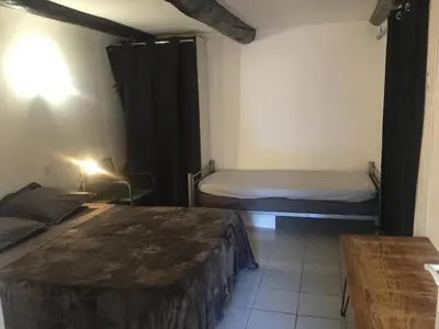 a small room with two beds and a table at Logement sur pte cour, rez de chaussée, WIFI, CLIM in Vedène