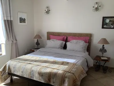 a bedroom with a large bed with pink and white pillows at jardin d'antan in Ansouis