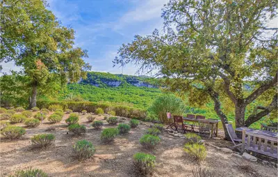 a park with benches and plants and a view of a mountain at Awesome Home In Bonnieux With Sauna in Bonnieux