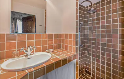 a bathroom with a sink and a shower with a mirror at Awesome Home In Bonnieux With Sauna in Bonnieux