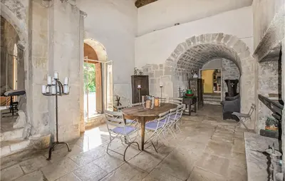 a dining room with a table and chairs and an archway at Awesome Home In Bonnieux With Sauna in Bonnieux