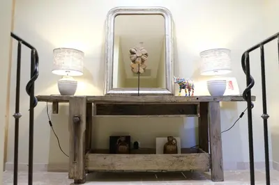 a console table with two lamps and a mirror at charming house with private pool in the heart of the village of aureille in the alpilles, 6 people. in Aureille