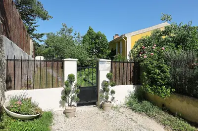 a fence with potted plants in front of a gate at Chambre d'hôte Mas de Silvacane in La Roque-dʼAnthéron