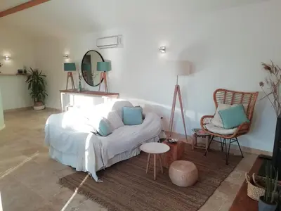 a bedroom with a bed and a chair and a mirror at Villa pleine campagne, piscine chauffée , Lubéron in Lacoste