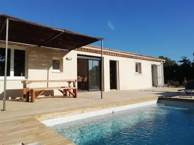 a house with a wooden deck and a swimming pool at Villa pleine campagne, piscine chauffée , Lubéron in Lacoste