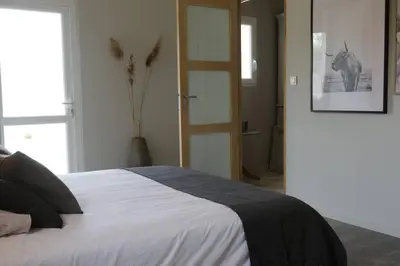 a bedroom with a bed and a door to a room at Villa pleine campagne, piscine chauffée , Lubéron in Lacoste