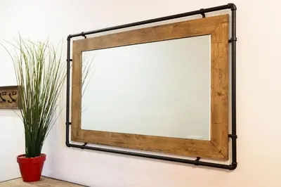 a mirror with a black metal frame on a wall at Bricks Industry Hyper Centre Fontaine Moussue in Salon-de-Provence