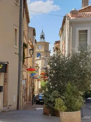 a city street with a clock tower and an umbrella at Bricks Industry Hyper Centre Fontaine Moussue in Salon-de-Provence