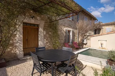 a black table and chairs in front of a house at Le Mas des Sablières in Oppède