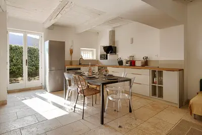 a kitchen and dining room with a table and chairs at Le Mas des Sablières in Oppède