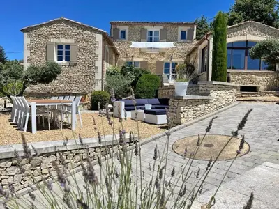 a stone house with a patio and a table and chairs at Villa Abayers in Apt
