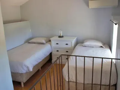 a bedroom with two beds and a dresser with a night stand at Grands Abayers in Apt