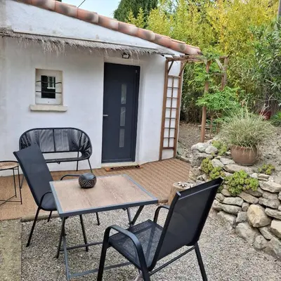 a patio with a table and chairs in front of a house at La Micocoule in La Barben