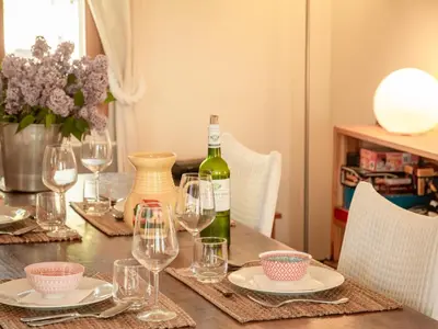 a dining room table with a bottle of wine and glasses at Villa Bellegarde in Saignon